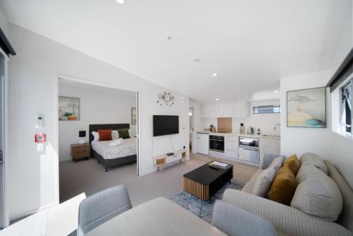 a living room with a couch and a bedroom at Wynter Apartments in Queenstown