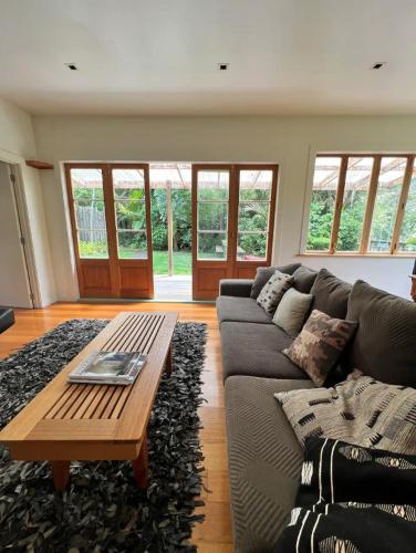 sala de estar con sofá y mesa de centro en Forest Hideaway ~ Rustic, en Coromandel