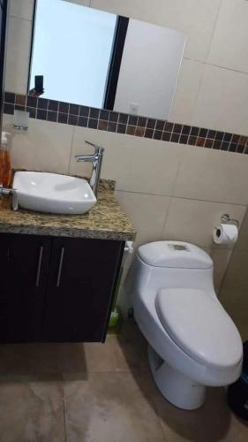 ein Badezimmer mit einem weißen WC und einem Waschbecken in der Unterkunft Deymar_ tonsupa in Tonsupa