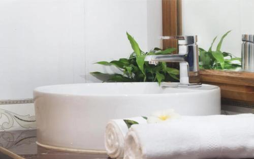 a bathroom sink with a roll of toilet paper at Keanthay Guest House in Battambang