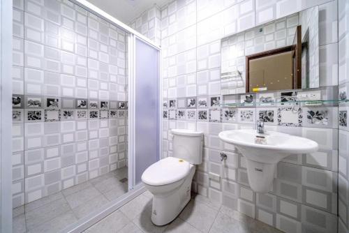 een witte badkamer met een toilet en een wastafel bij Little House Homestay in Wujie