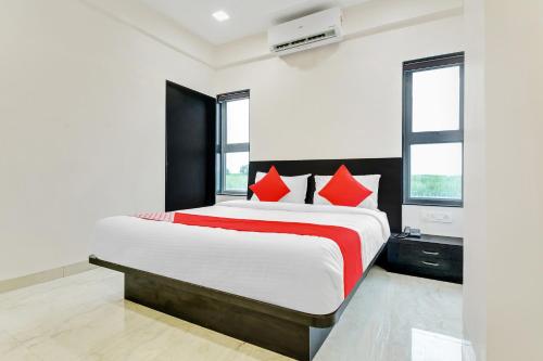 1 dormitorio con 1 cama grande con almohadas rojas en Flagship V&s Hotel, en Pimpalgaon