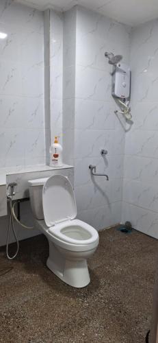 uma casa de banho com um WC branco num quarto em Norita Homestay PD em Porto Dickson