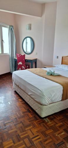 1 dormitorio con 1 cama grande y suelo de madera en Norita Homestay PD, en Port Dickson