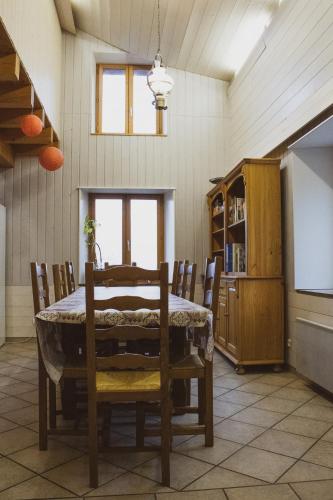 une salle à manger avec une table, des chaises et un écran dans l'établissement Gites les Plombes, à Xonrupt-Longemer