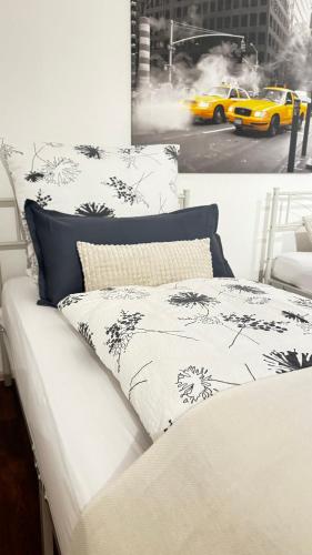 a bed with black and white sheets and a yellow taxi at Smart Stay Apartment in Balingen in Balingen