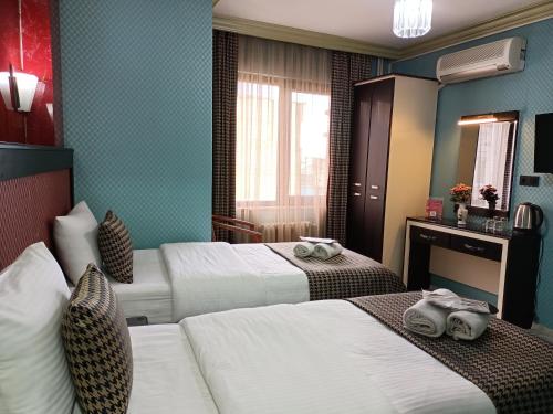 イスタンブールにあるHotel Falconのベッド2台と鏡が備わるホテルルームです。