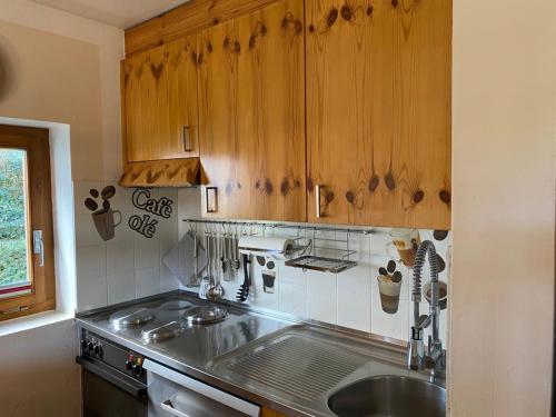 a kitchen with wooden cabinets and a sink at Flims Chalet in Flims