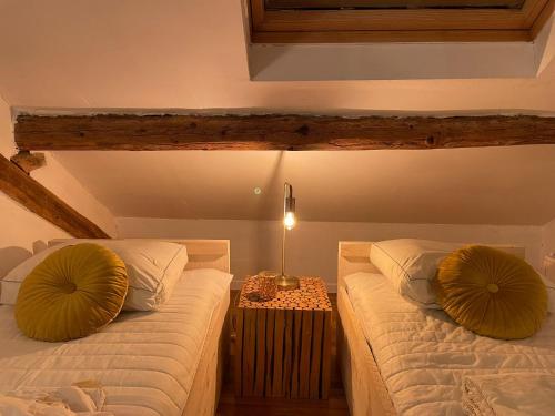 Les Lavandes de Durbuy في دربي: غرفة نوم بسريرين ومصباح على طاولة