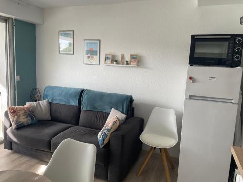 - un salon avec un canapé et un réfrigérateur dans l'établissement Charming appartment in the heart of La Palmyre, aux Mathes