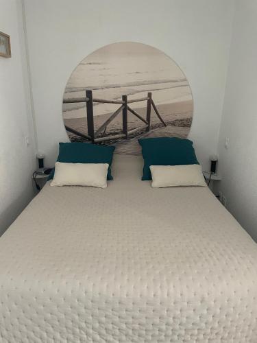 - une chambre avec un grand lit blanc et une fenêtre circulaire dans l'établissement Charming appartment in the heart of La Palmyre, aux Mathes