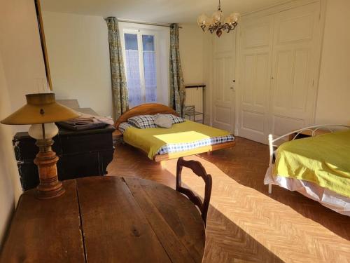 a room with a table and a bed and a table sidx sidx sidx at Gite la ferme des maraîchers in Albigny-sur-Saone