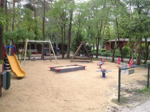 een speeltuin met een heleboel speeltoestellen in een park bij Boschalet Noord Veluwe in Doornspijk