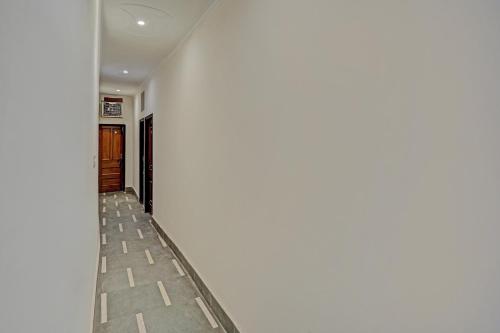 un corridoio con parete bianca e pavimento di OYO Hotel Jmd Residency a Shāhdara