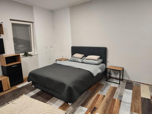 a bedroom with a bed with a black headboard at Maky Apartment in Bački Petrovac