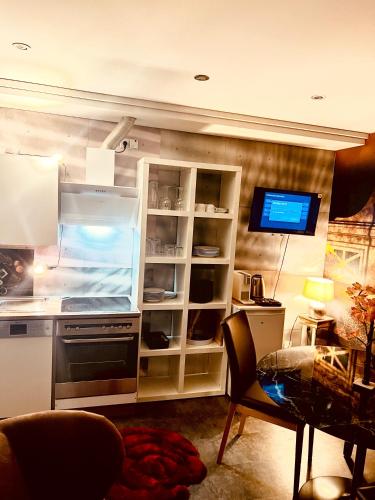 a kitchen with a stove and a tv in a room at Luxurious Apartment with Sauna in Cologne