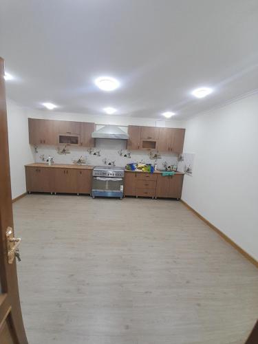 a large kitchen with wooden cabinets and a stove at Amina Hotel boutique in Bukhara