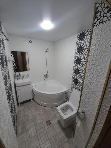 a bathroom with a tub and a toilet and a sink at Amina Hotel boutique in Bukhara