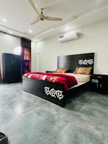 a bedroom with a large bed with a red blanket at AS Plaza in Gujrānwāla