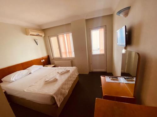 SANCAK HOTEL في بيوك شكمجه: غرفة نوم صغيرة بها سرير وتلفزيون