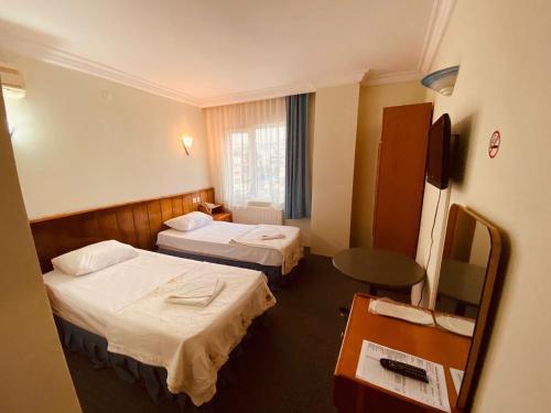 a hotel room with two beds and a television at SANCAK HOTEL in Buyukcekmece