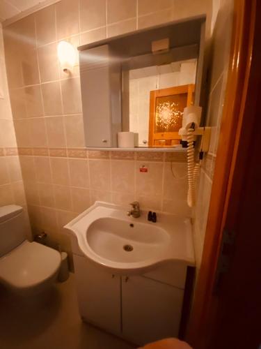 a bathroom with a sink and a toilet and a mirror at SANCAK HOTEL in Buyukcekmece