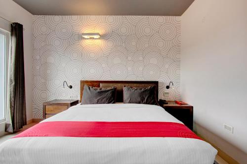 een slaapkamer met een groot bed en een rode deken bij Super Collection O Palm Tree Ulsoor in Bangalore