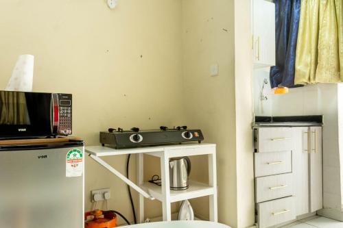 a small kitchen with a stove and a refrigerator at T's Place in Nairobi