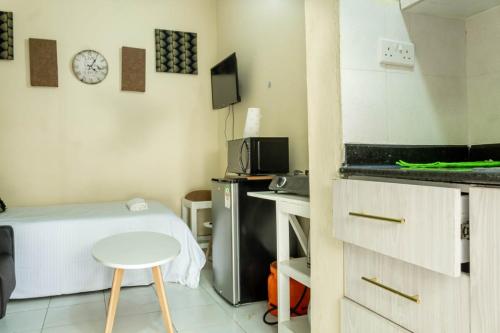 a room with a bed and a table and a microwave at T's Place in Nairobi