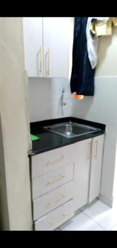 a kitchen with a sink and a black counter top at T's Place in Nairobi