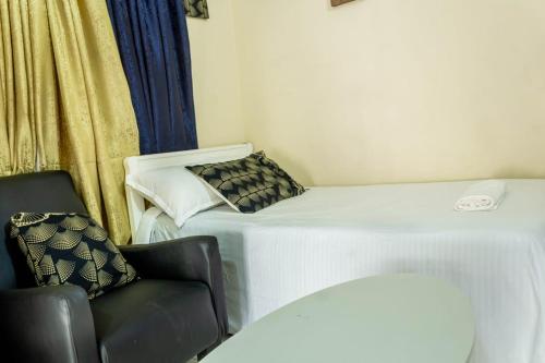 a small room with a bed and a chair at T's Place in Nairobi