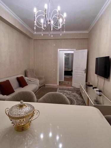 sala de estar con mesa y lámpara de araña en Apartment Samir mida en Bakú