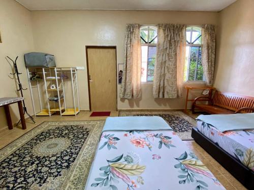 1 Schlafzimmer mit 2 Betten und 2 Fenstern in der Unterkunft COZY GL Roomstay ARAU in Kangar