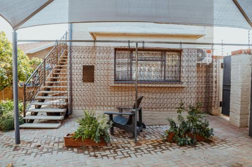 a patio with a staircase and a table with plants at Ons Dorpshuis Guesthouse in Rustenburg