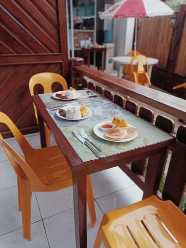 a wooden table with plates of food on it at Neela Tourist Lodge in El Nido
