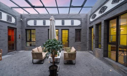a patio with two chairs and a umbrella at Hotel Cote Cour Deductive Beijing - Quadrangle close to Tiananmen Square & Forbidden City & Nanluoguxiang, Walk to Wangfujing, English speaking, Free WiFi, Free Laundry, Free Wonton & Noodles with Tour ticket service, Free selfies with ancient costume in Beijing