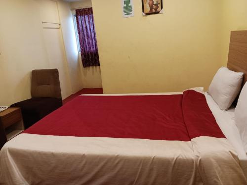 una camera con un letto con una coperta rossa e bianca di FLGHR Crazy Home Stay a Kodaikānāl