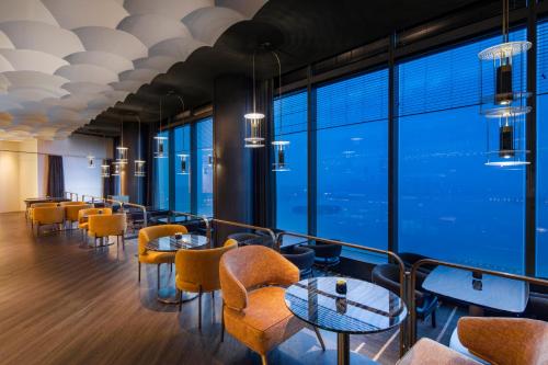 a restaurant with tables and chairs and large windows at W Suzhou - Jinji Lake in Suzhou