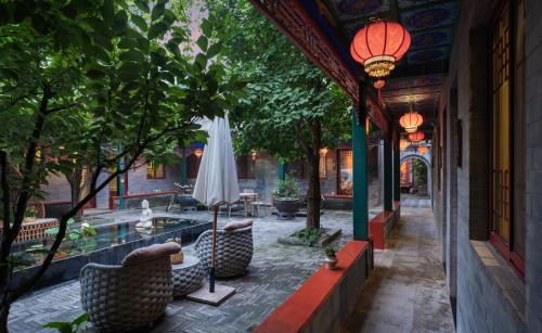 a patio with a table and a white umbrella at Hotel Cote Cour Deductive Beijing - Quadrangle close to Tiananmen Square & Forbidden City & Nanluoguxiang, Walk to Wangfujing, English speaking, Free WiFi, Free Laundry, Free Wonton & Noodles with Tour ticket service, Free selfies with ancient costume in Beijing
