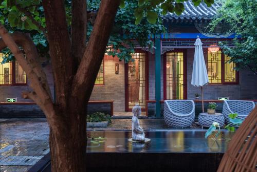 a statue sitting on a table next to a tree at Hotel Cote Cour Deductive Beijing - Quadrangle close to Tiananmen Square & Forbidden City & Nanluoguxiang, Walk to Wangfujing, English speaking, Free WiFi, Free Laundry, Free Wonton & Noodles with Tour ticket service, Free selfies with ancient costume in Beijing