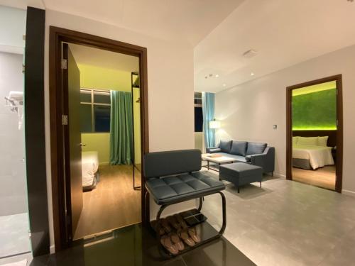 a living room with a chair and a couch and a mirror at NEWCC HOTEL AND SERVICED APARTMENT in Quang Ngai