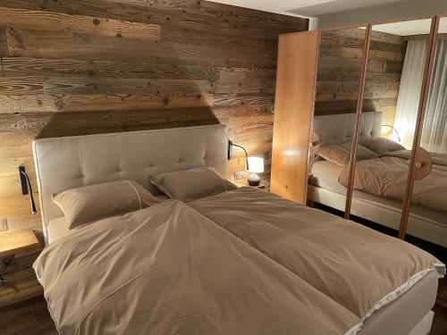 a bedroom with a large bed and a mirror at Appartement Everest in Zermatt