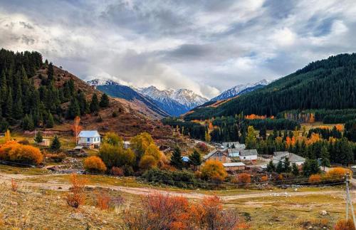 a small town in a valley with mountains at Кереге-Таш in Karakol