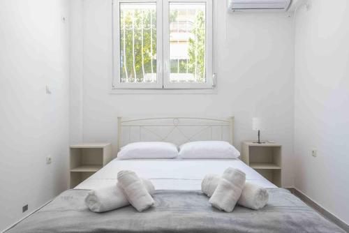 um quarto branco com uma cama com almofadas em Athens Comfy Apartment- near Acropolis em Atenas
