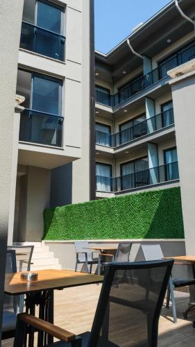 a patio with tables and chairs in front of a building at MYWAY DELUXE Alsancak in Konak