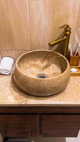 a sink with a gold faucet in a bathroom at Colette Hotel in Yerevan