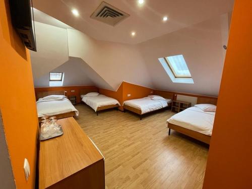 a room with two beds and a table in it at Pensiunea Relax in Râmnicu Vâlcea