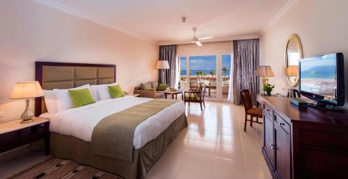 um quarto de hotel com uma cama grande e uma televisão em Baron Resort Sharm El Sheikh em Sharm El Sheikk