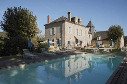 une grande piscine devant un immeuble dans l'établissement French Corréze Moulin Bleu, à Saint-Pantaléon-de-Larche