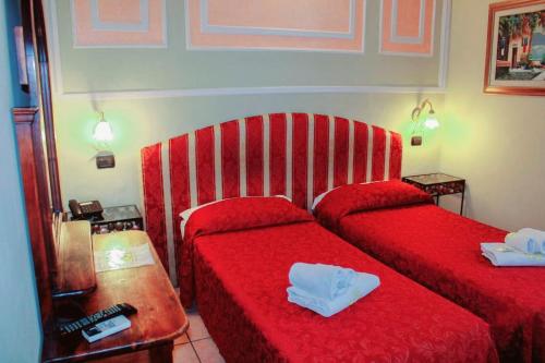 ミラノにあるVilla Lia Depandance Hotel Siciliaのホテルルーム ベッド2台(赤いシーツ付)